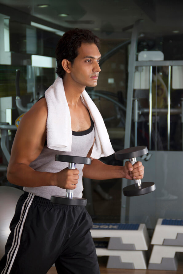 young male sweating hard at the gym while doing a workout