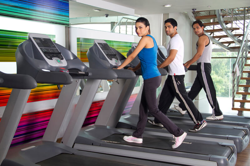 three youngsters looking at the camera while running on treadmills
