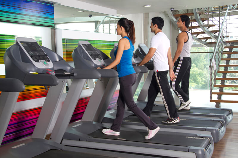 group of young teenagers running on treadmills