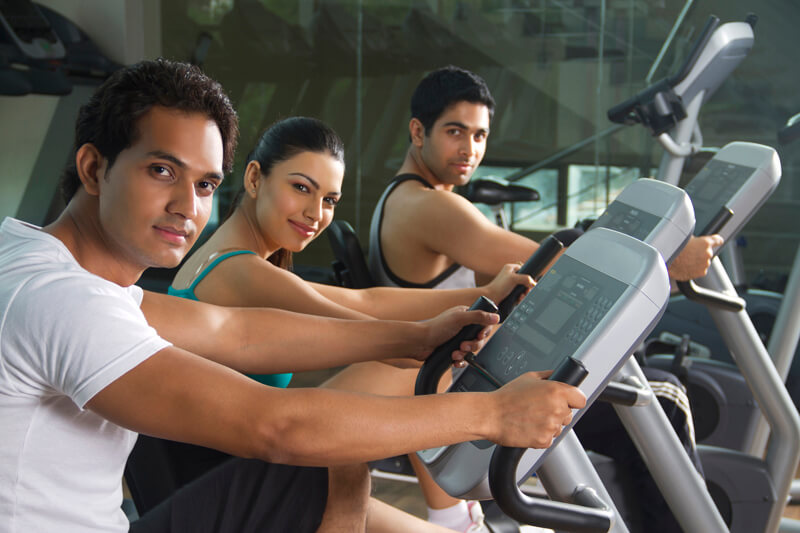 men and woman cycling at the gym