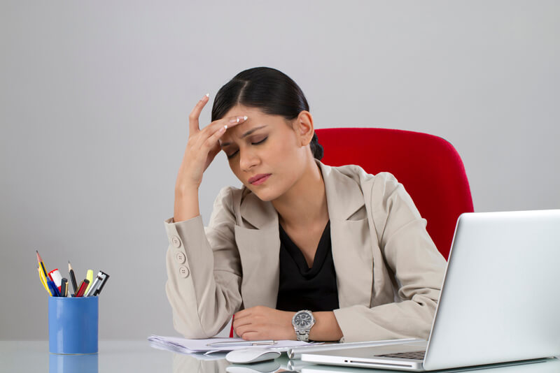 female executive suffering from headache at her office desk