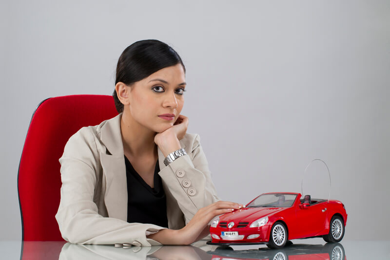 woman as ceo posing with a dummy car
