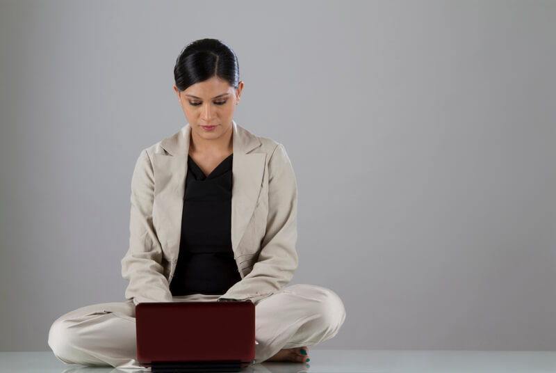 woman sitting down and looking at the laptop