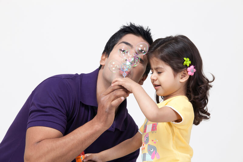 man and a little girl blowing bubbles