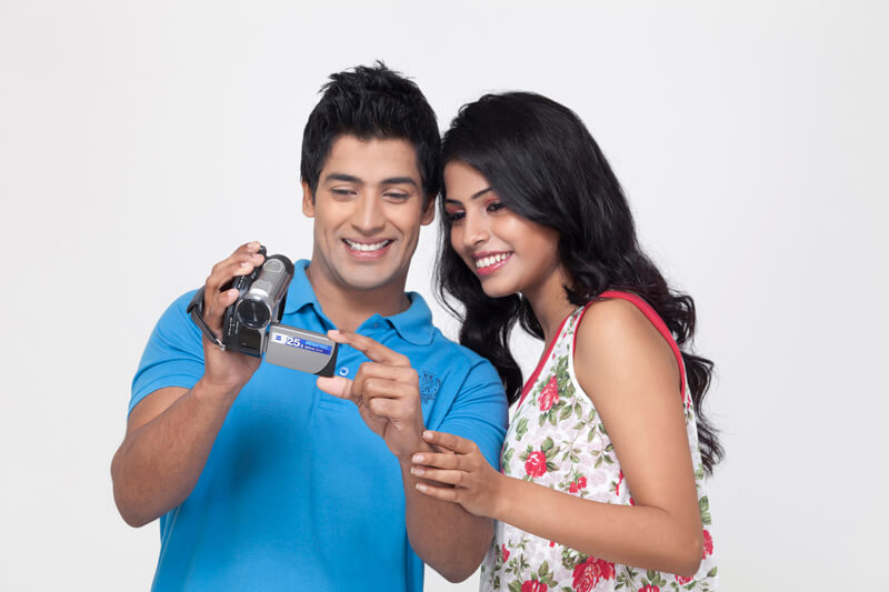 couple smiling while watching video recording