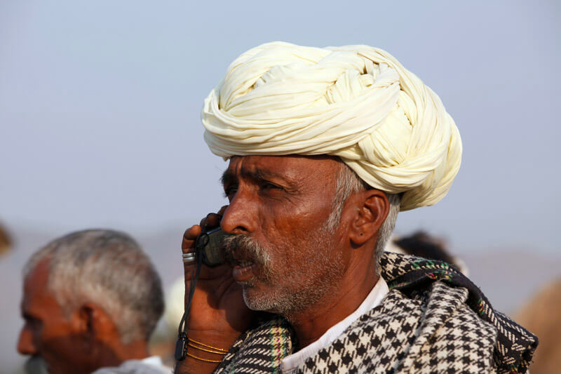 rural mean wearing turban talking on phone 