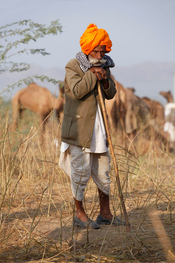 rural man standing with a laathi 