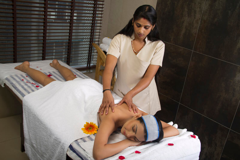 therapist giving massage at spa centre