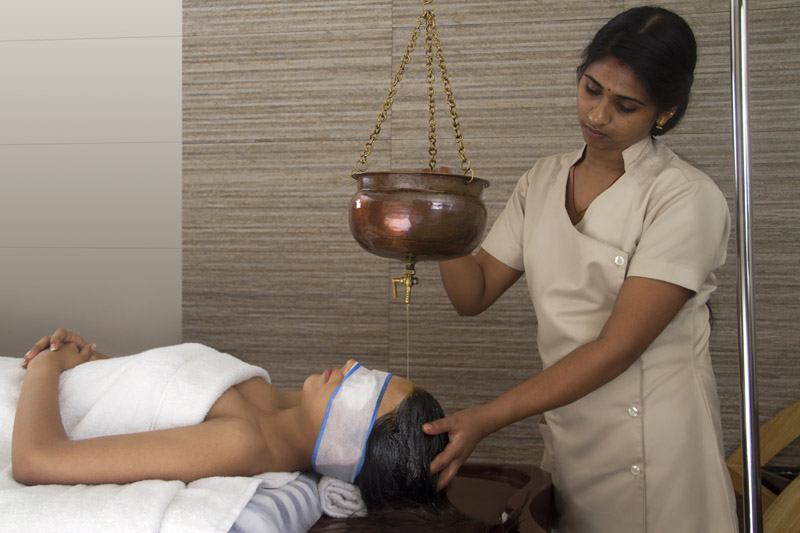 woman therapist applying oil at spa center 