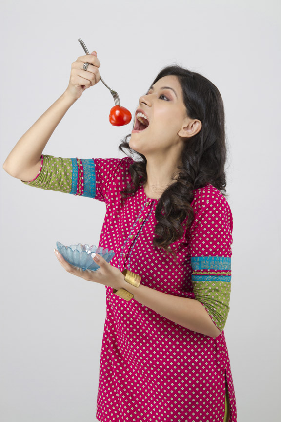 woman taking ready to eat raw tomato