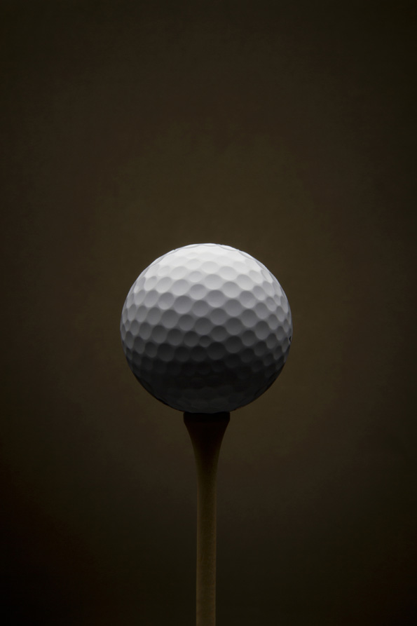 Golf ball with dark brown background