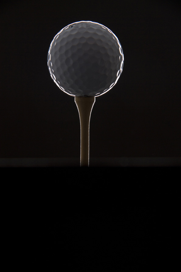 close up shot of golf ball against dark background 