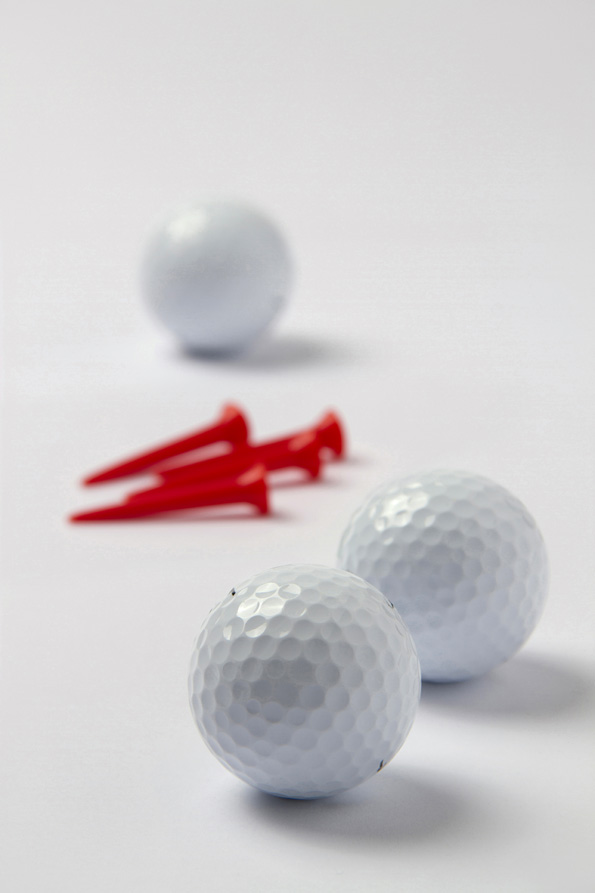 golf balls and golf tees on a white surface