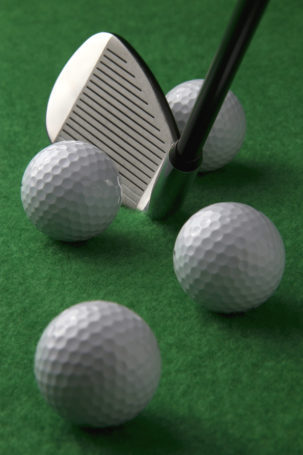 golf club and golf balls on a green background