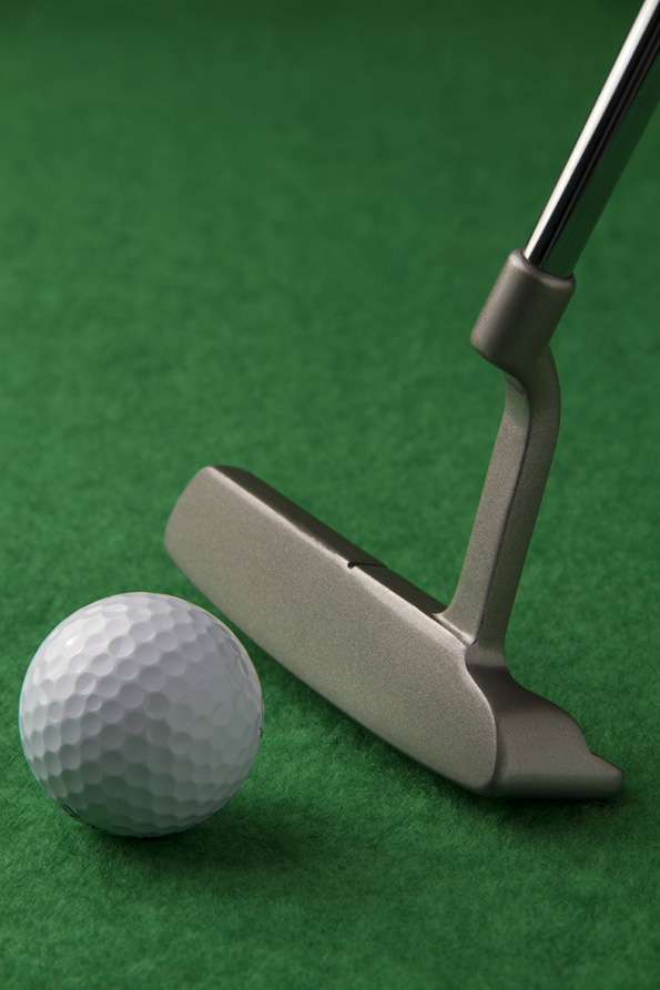 golf club and golf ball on a green background