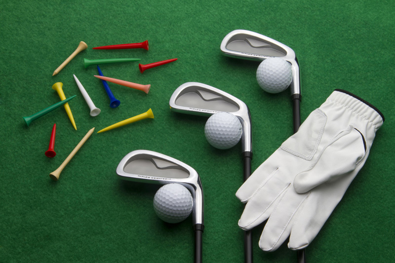 different golf accessories on green background