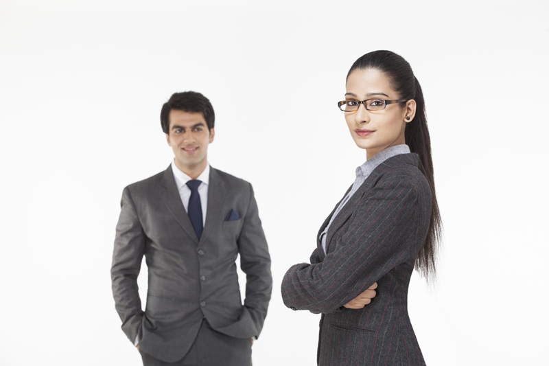 businesswoman posing while male executive looking at her 