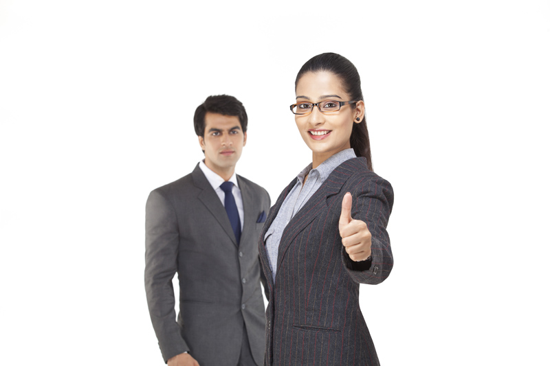 female executive showing thumbs up while male executive looking in the