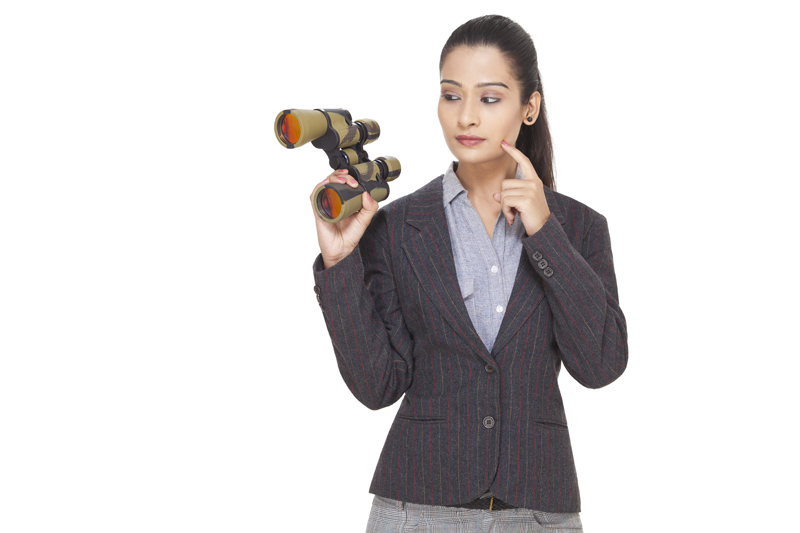 businesswoman posing while holding a binocular