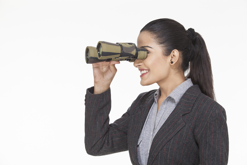 woman smiling while looking with binocular