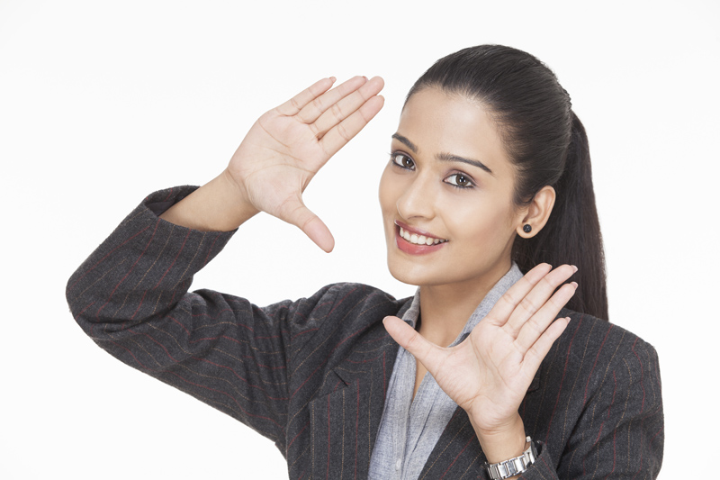 beautiful young businesswoman posing while framing with hands