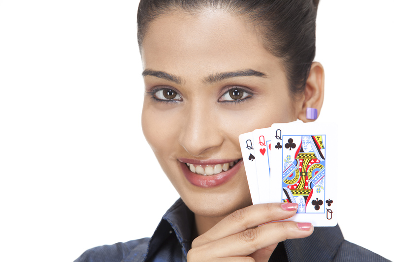 girl holding playing cards while posing for the camera