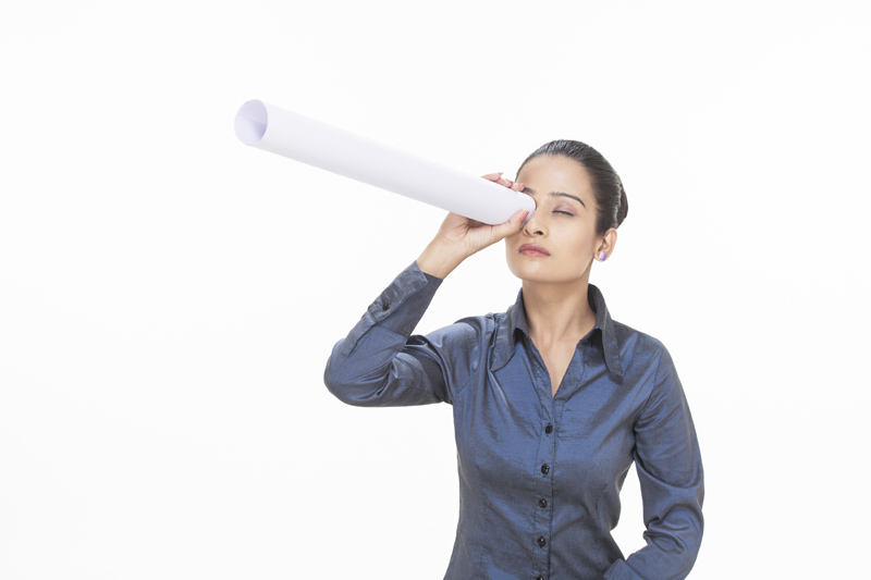 girl looking through rolled chart paper