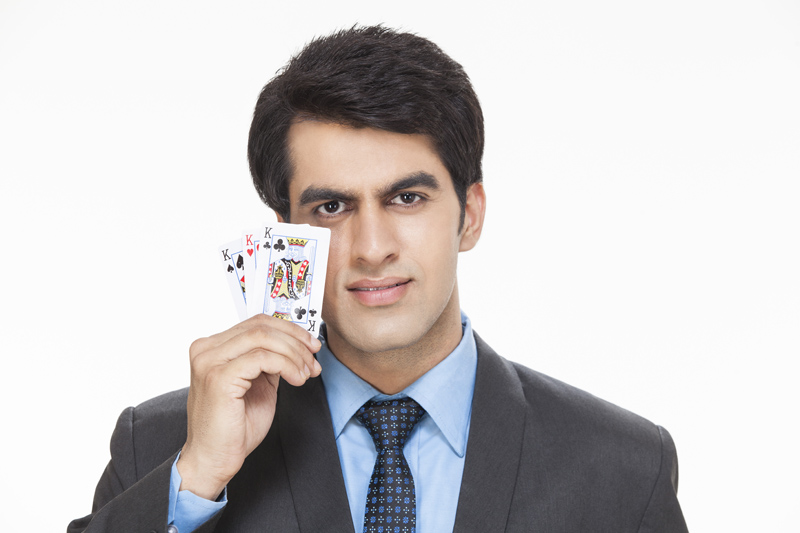 businessman smiling while posing with cards