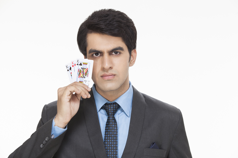 businessman holding playing cards and posing 