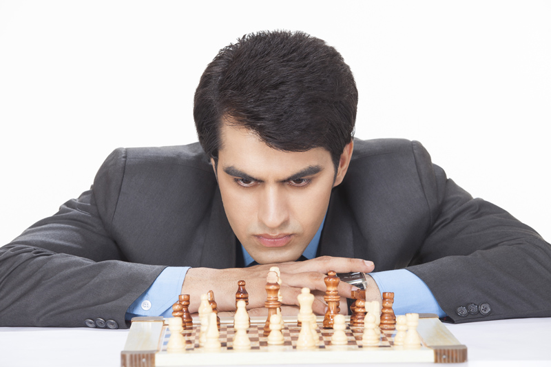 young entrepreneur in deep thinking while playing chess