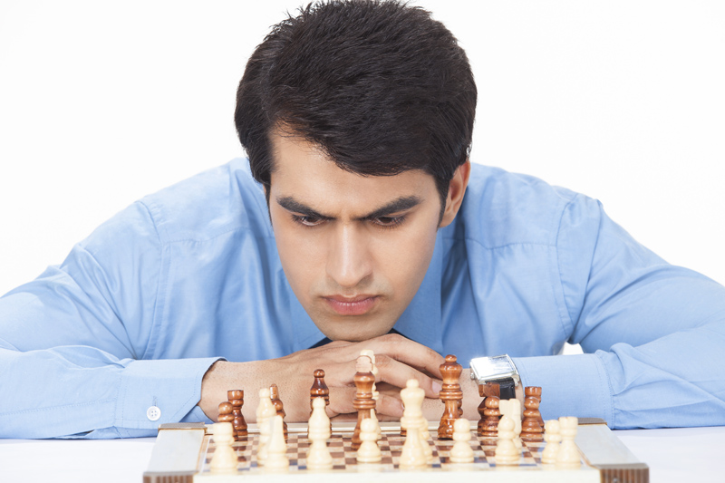 young businessman looking at chess board in deep thinking