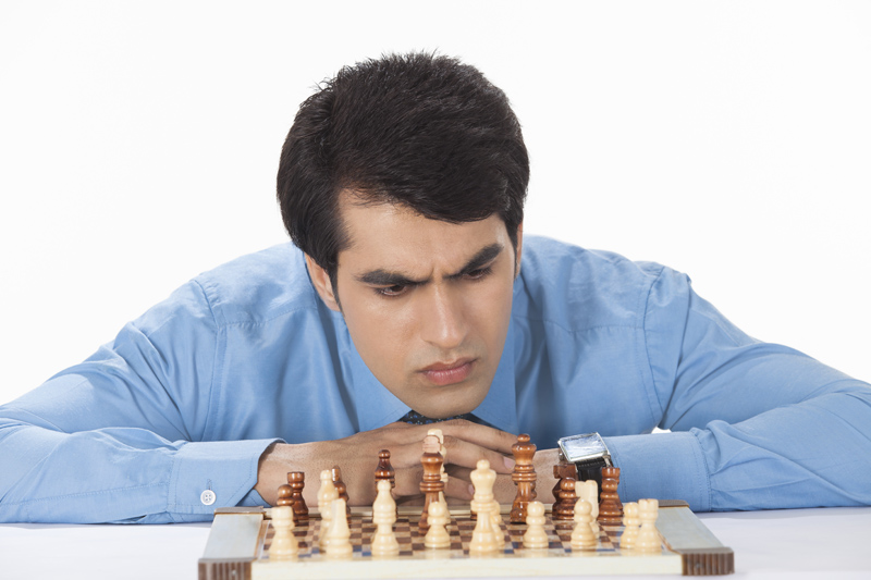 man intensely looking at chess board