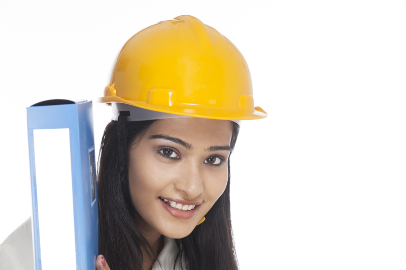 girl carrying folder and posing in hardhat
