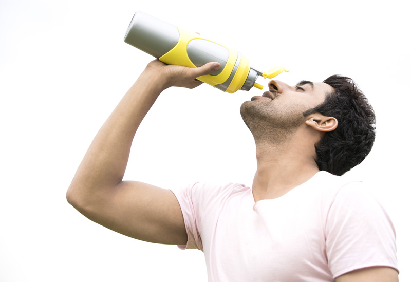 man drinking energy drink from bottle 