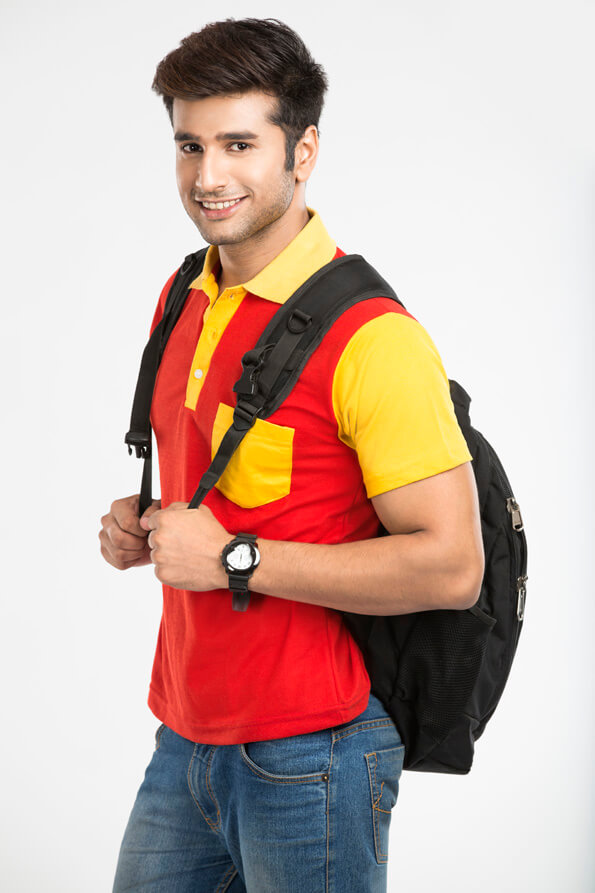 guy posing while holding bag straps 
