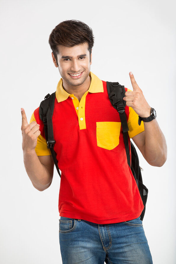 guy carrying backpack gesturing while looking at the camera 