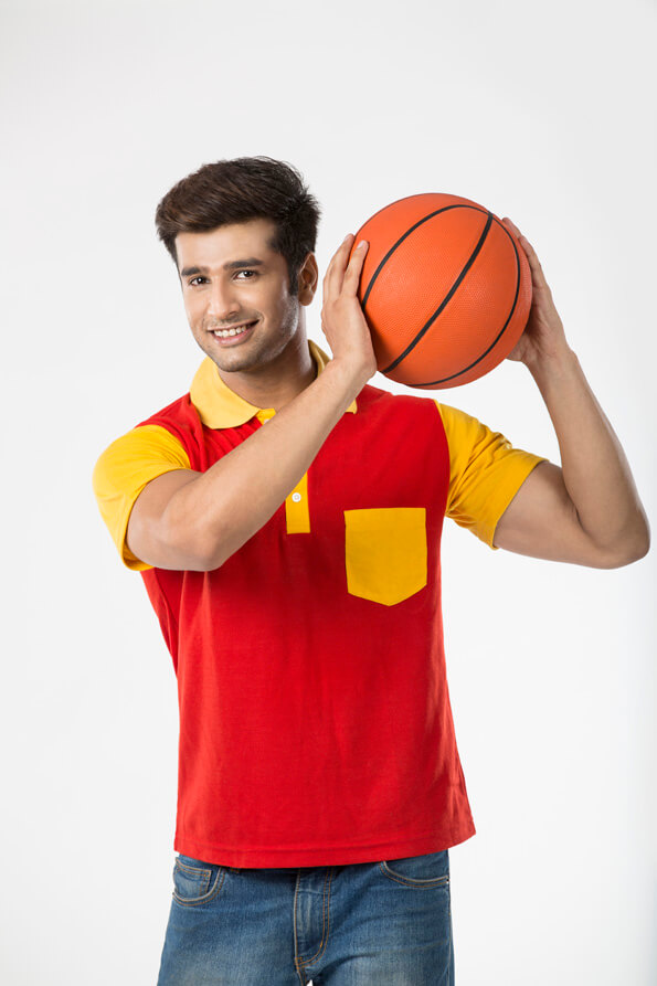 young guy posing while holding a basketball