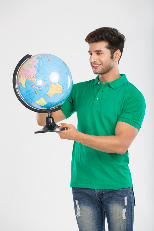 man smiling while holding a globe 
