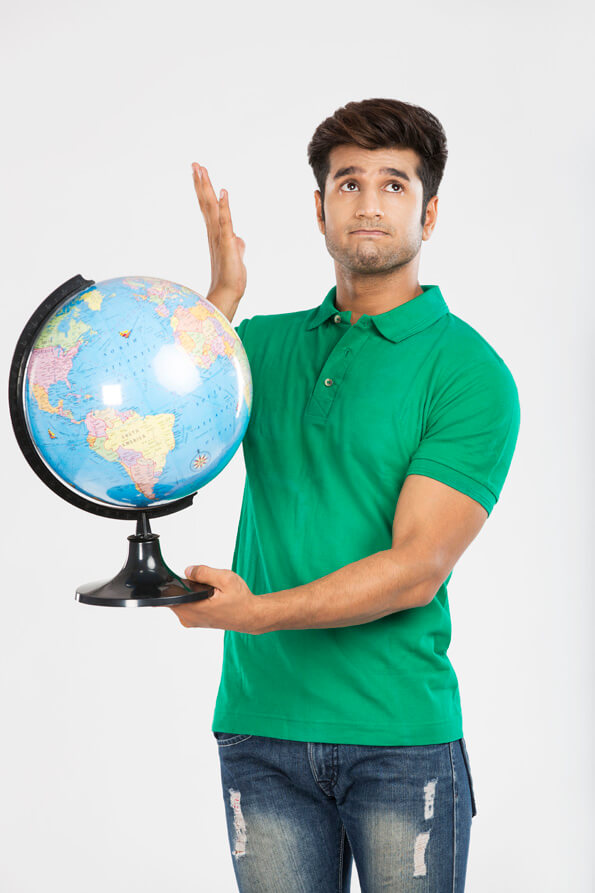 man confused and holding desktop globe 