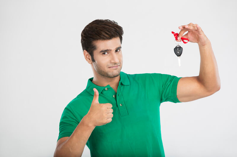 man showing thumbs up while holding a car key 