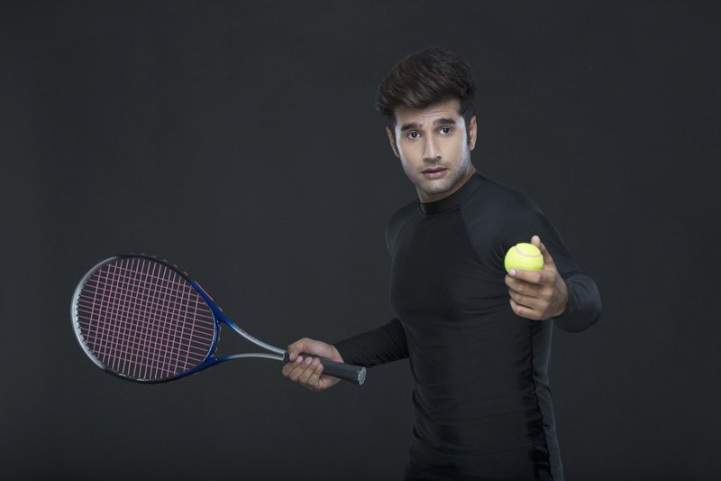 man holding tennis racket and ball