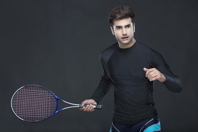 man holding tennis racket while posing for the camera 