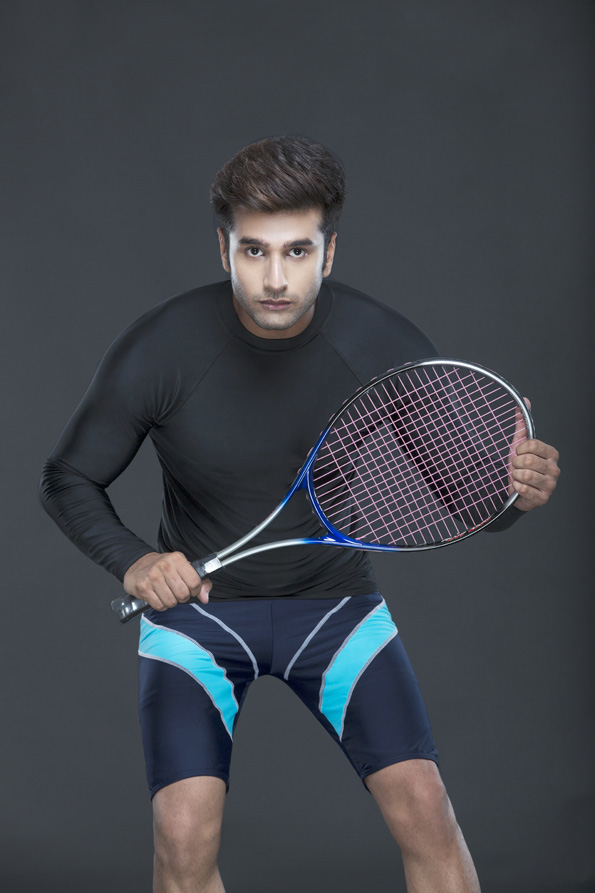 man looking at camera holding tennis racket 