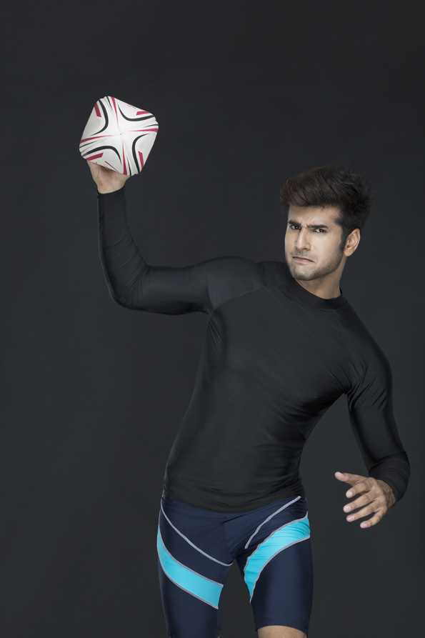 man posing while playing with rugby ball