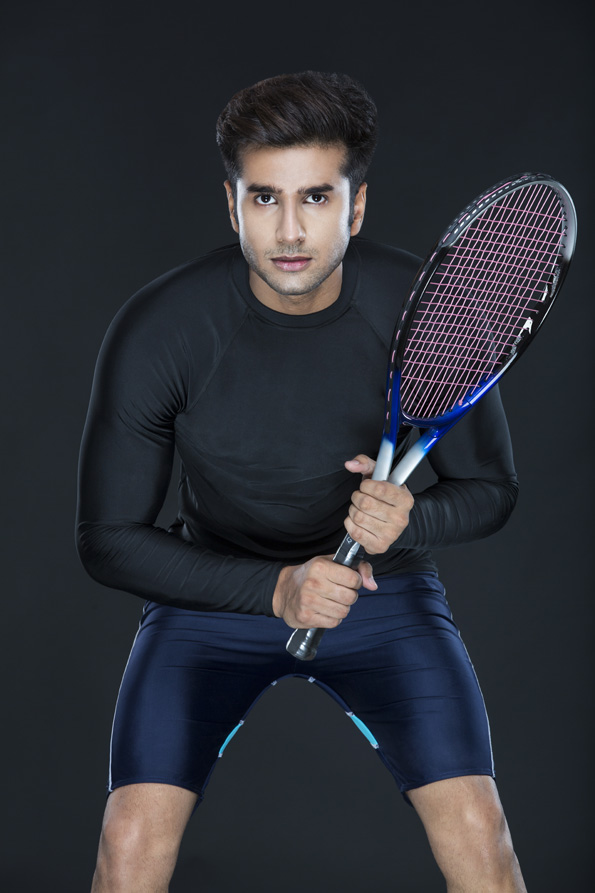 man looking at the camera while holding a tennis racket 
