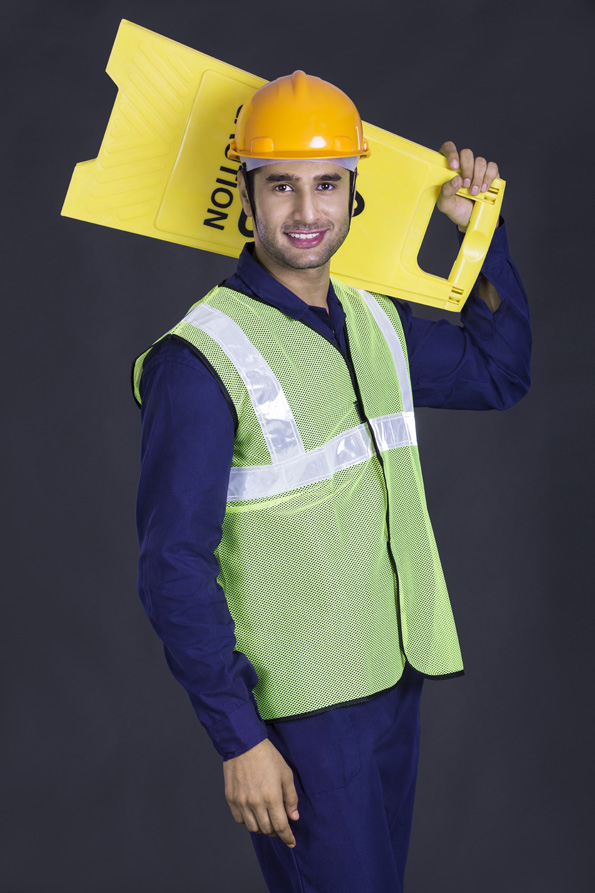 worker carrying caution stand while looking at the camera