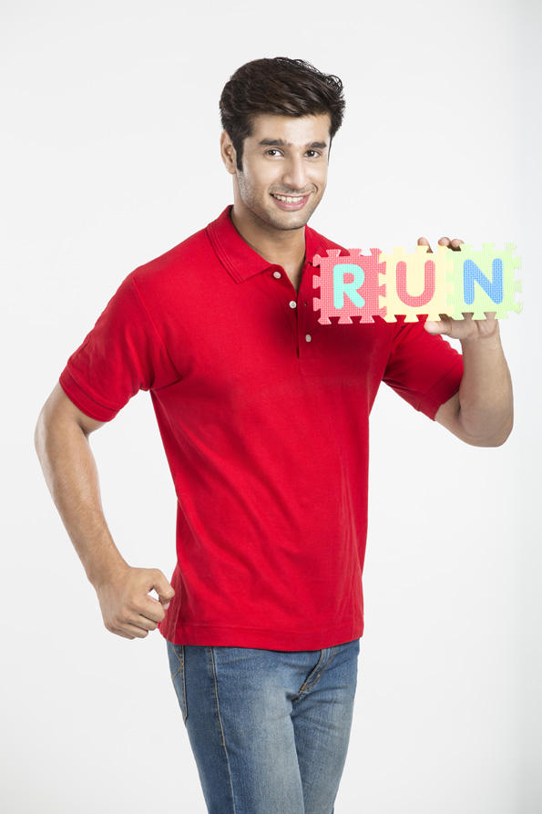young boy posing with the letter run while smiling 