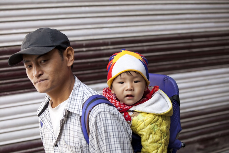 tibetan man carrying child on his back
