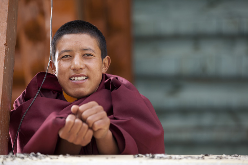 monk smiling and posing at the ladakh monastery
