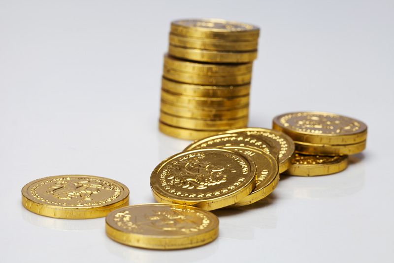 stack of gold coins lying against white background 